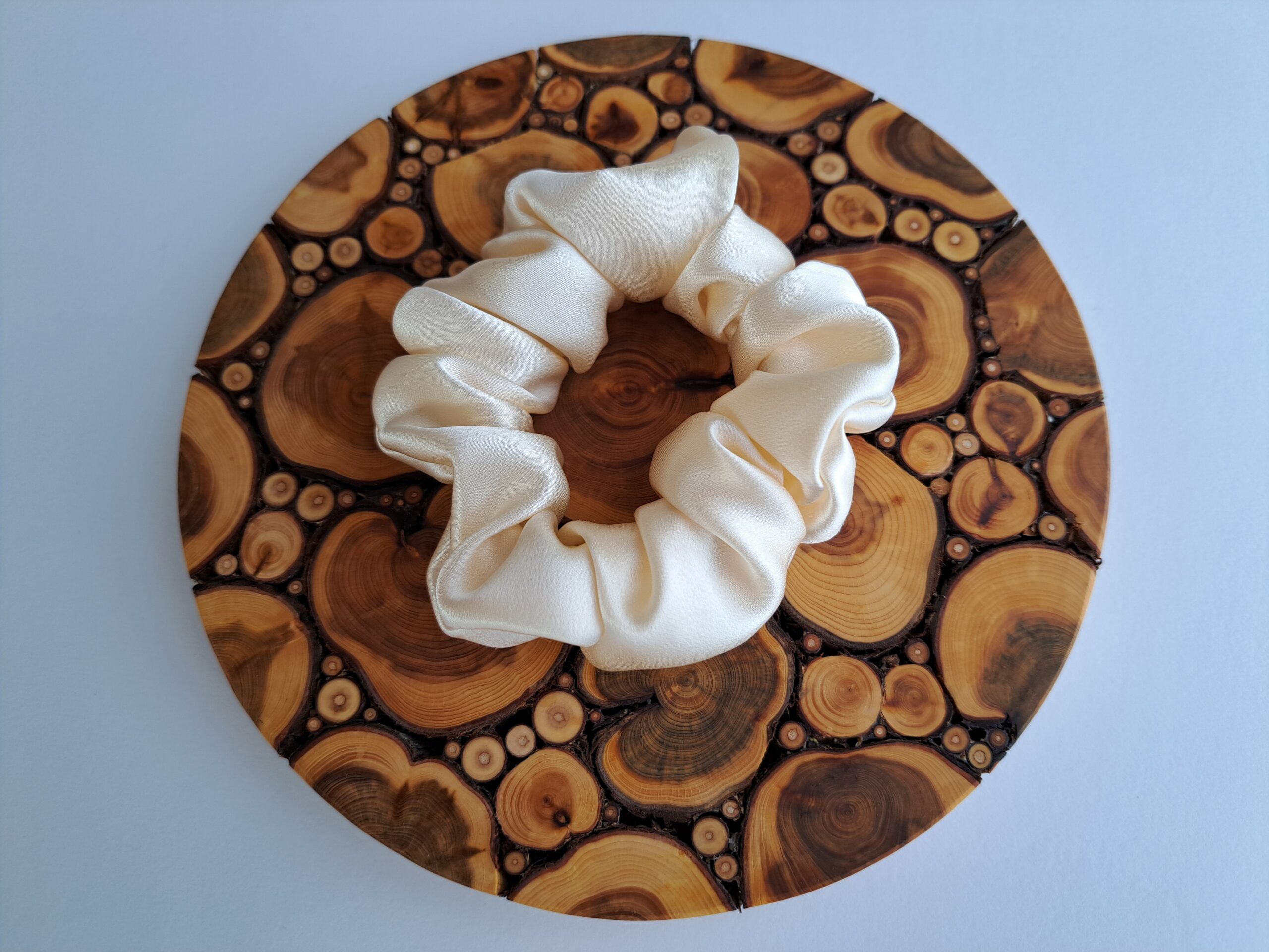 TalvEst siidist juuksekumm kreemikasvalge M puidu taustal